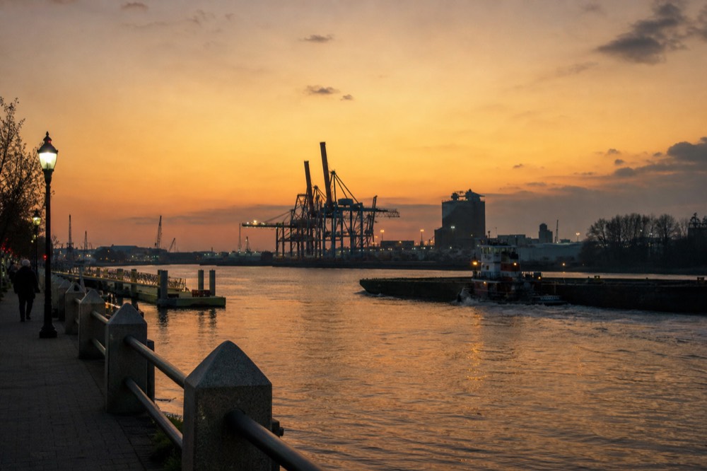 Container terminal cranes on the Savannah River at dusk, no text, no logos, no people