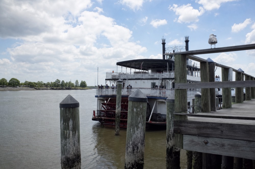 Paddlewheel riverboat moored along River Street with the Savannah River behind it, no text, no logos, no people