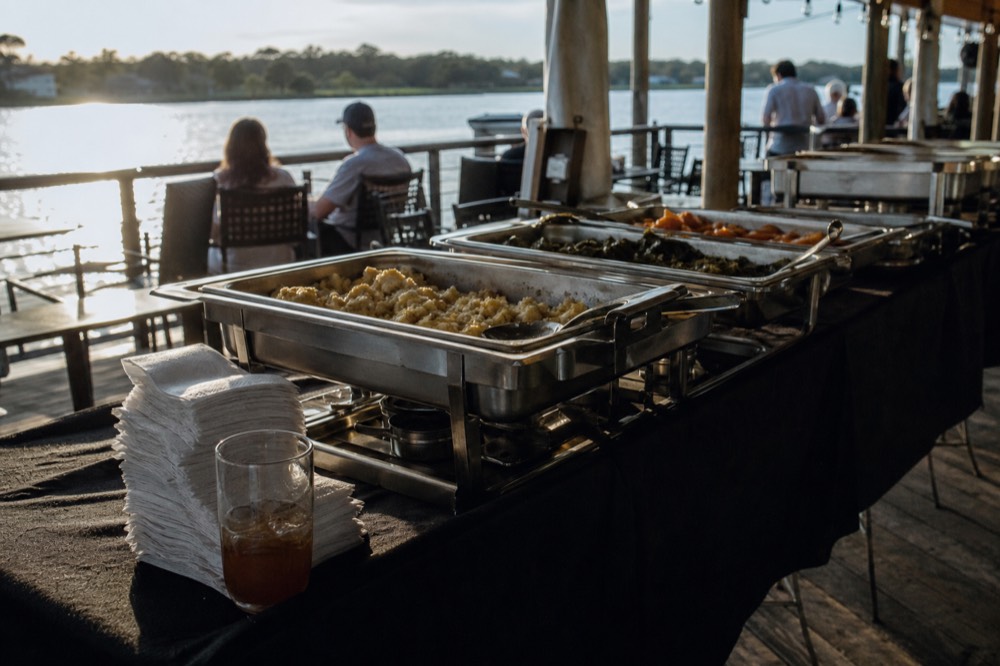 A riverboat buffet table with Southern dishes arranged on a dining deck, no text, no logos, no people