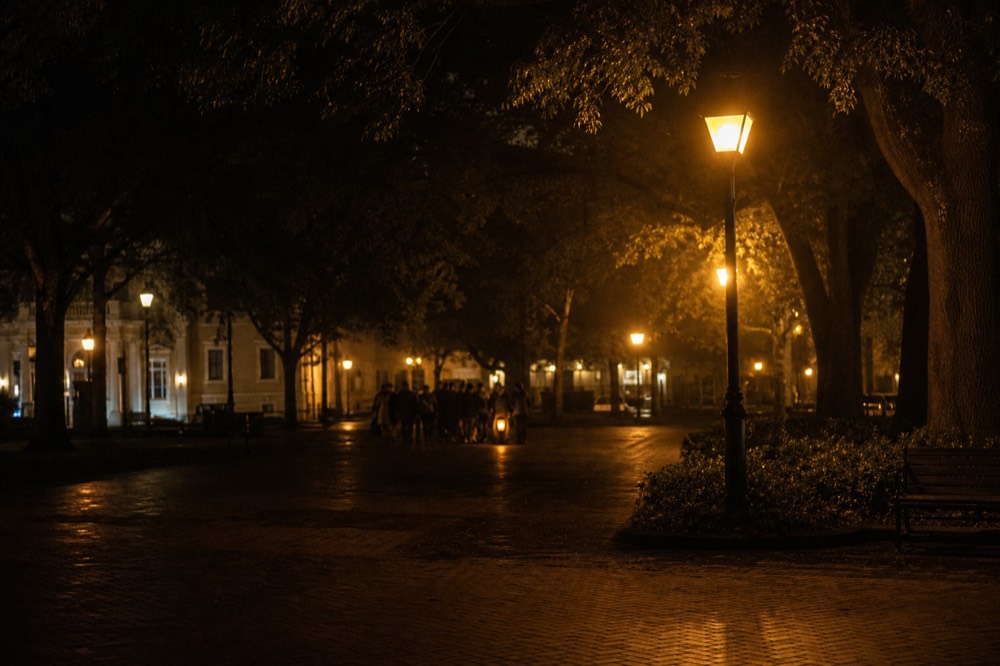 A historic square in Savannah at night with gas-style lamps, no text, no logos, no people