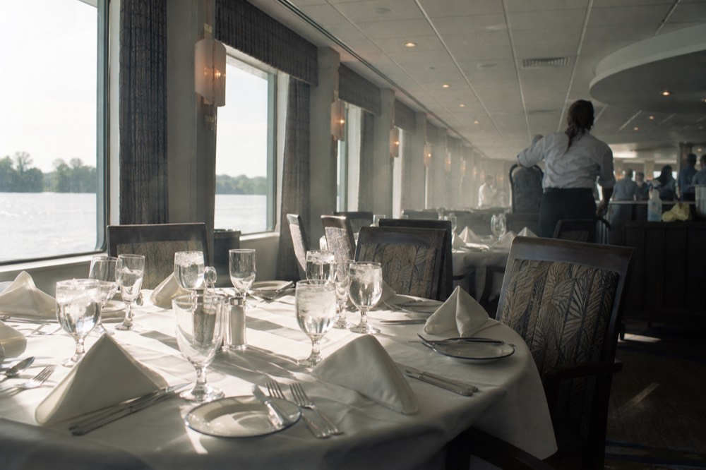 A set table on a climate-controlled riverboat dining deck before boarding, no text, no logos, no people