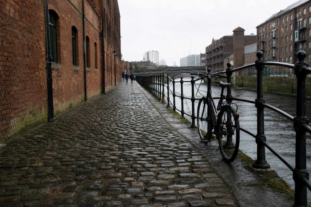 Cobblestones and historic brick warehouses along River Street, no text, no logos, no people