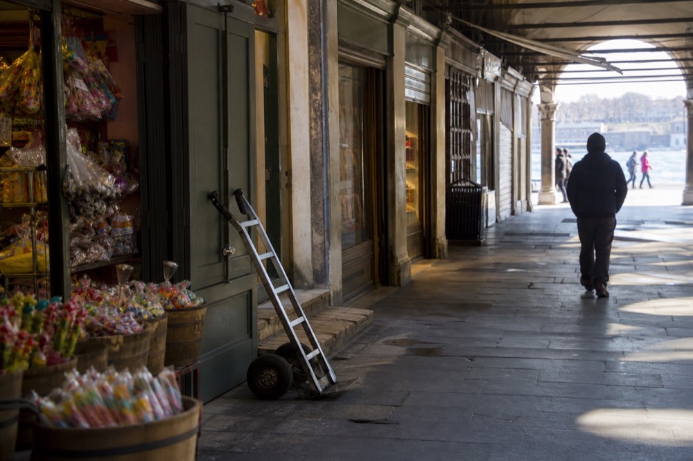 Shopfronts and candy stalls along the River Street warehouse row, no text, no logos, no people