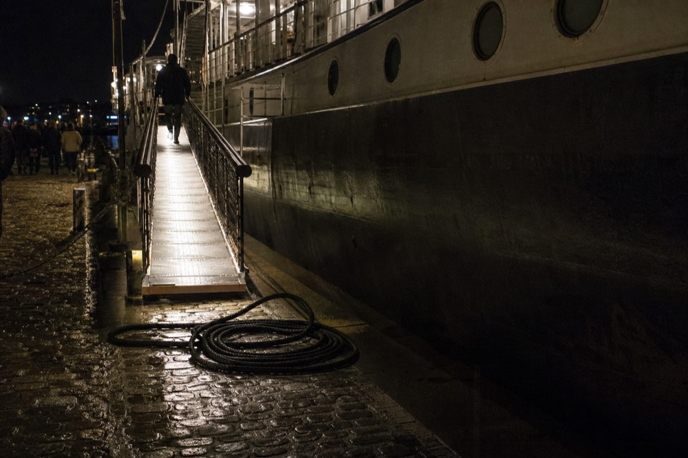 Riverboat dock on River Street at night with gangway lit, no text, no logos, no people