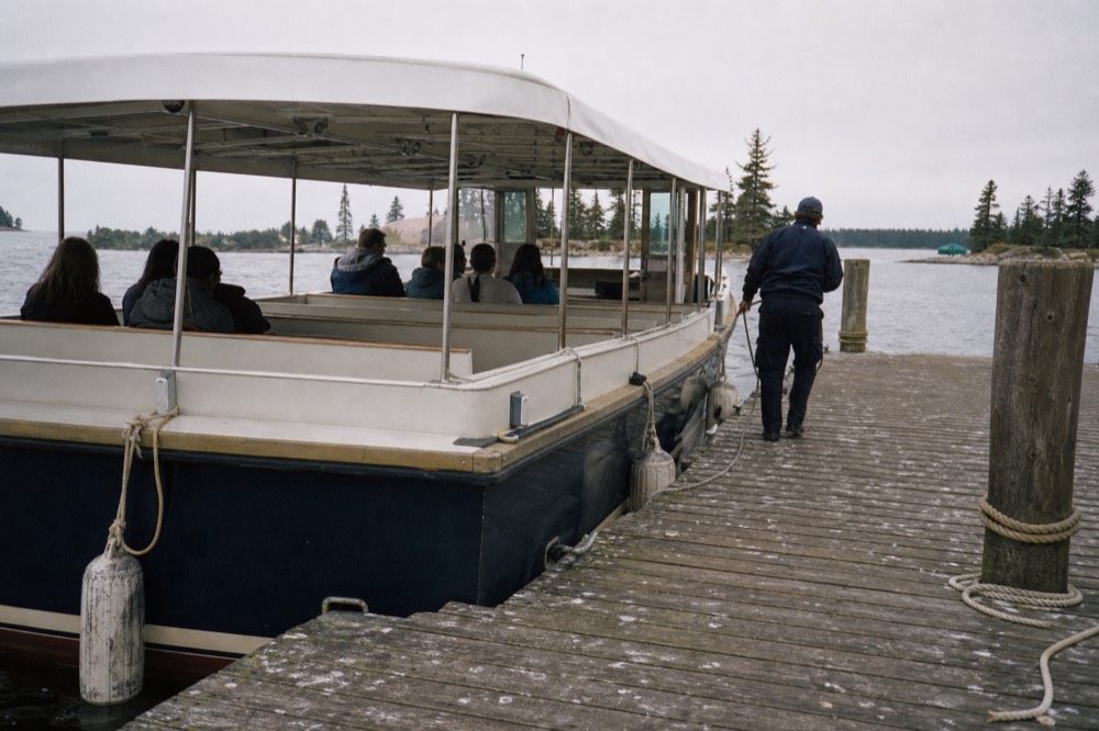 A tour boat idling at a riverfront dock near downtown Savannah at midday, no text, no logos, no people