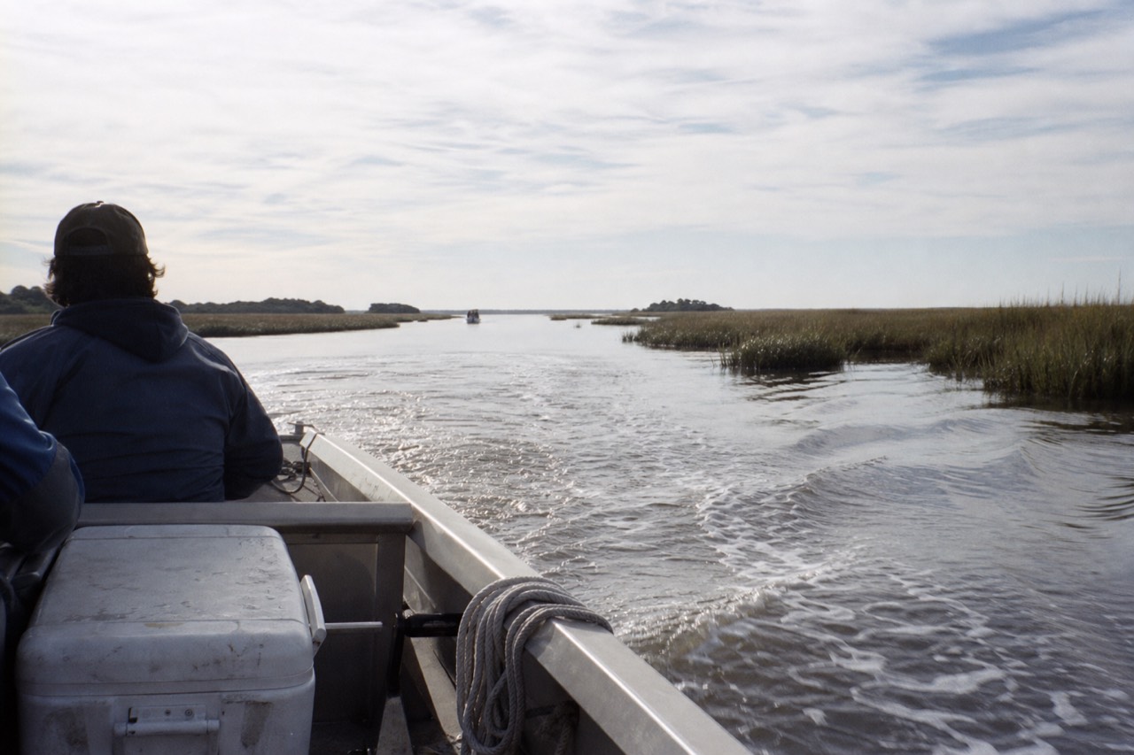 A small tour boat cutting across calm coastal Georgia water near Savannah, no text, no logos, no people