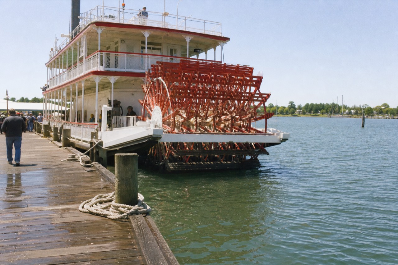A red and white paddlewheel riverboat moored along the Savannah River waterfront on a bright midday, no text, no logos, no people