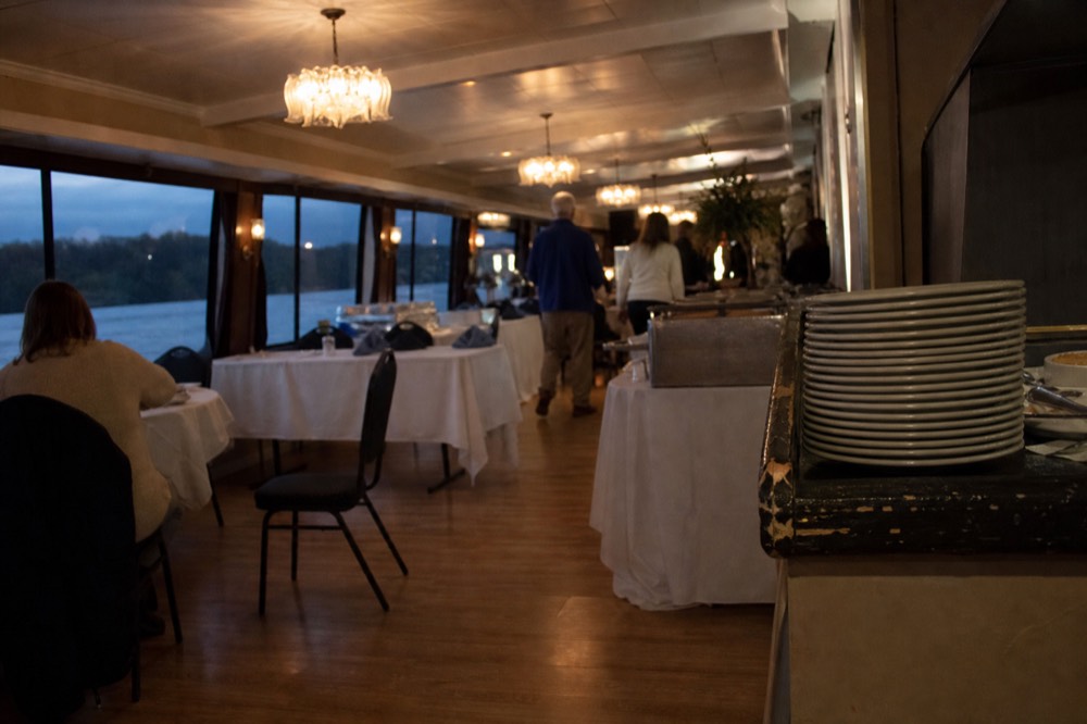 Interior dining deck of a riverboat set for a buffet dinner, no text, no logos, no people